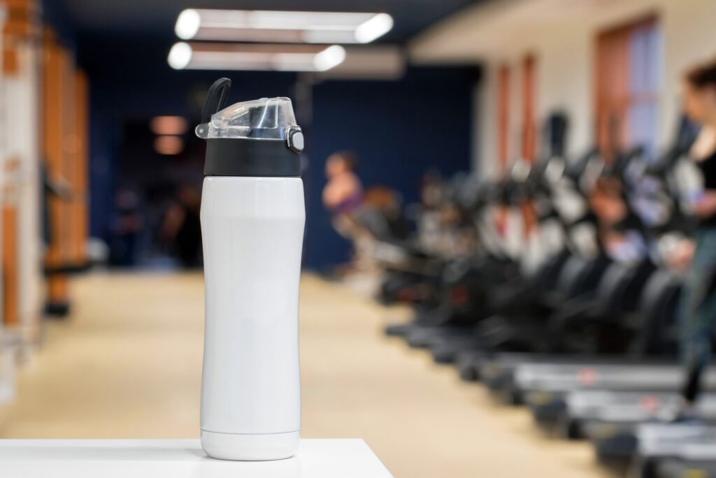 Plastic bottle or cup with fitness drink close up