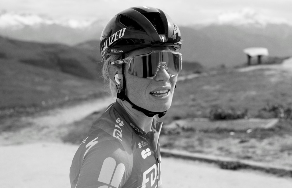 Skärmavbild 2026-05-08 kl 083505 - Aktivitus Professional cyclist in racing gear, wearing a helmet and visor, outdoors in a mountainous landscape.